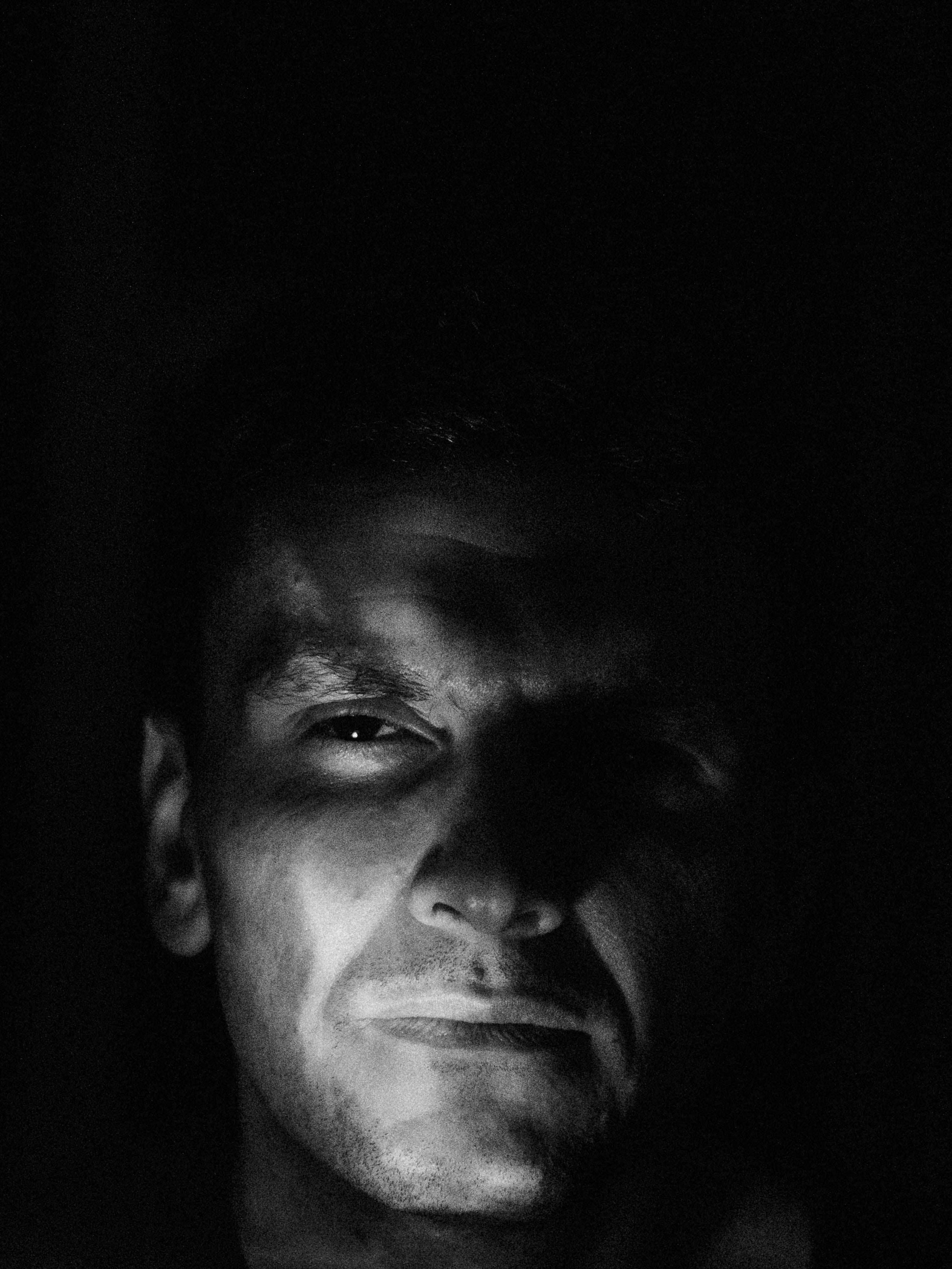 Black and white portrait, face emerging from shadow
